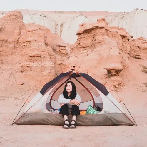 Woman in tent in the desert wearing hiking sandals