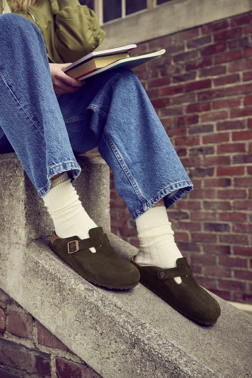 Person wearing dark Birkenstock Boston clogs with jeans and light socks.