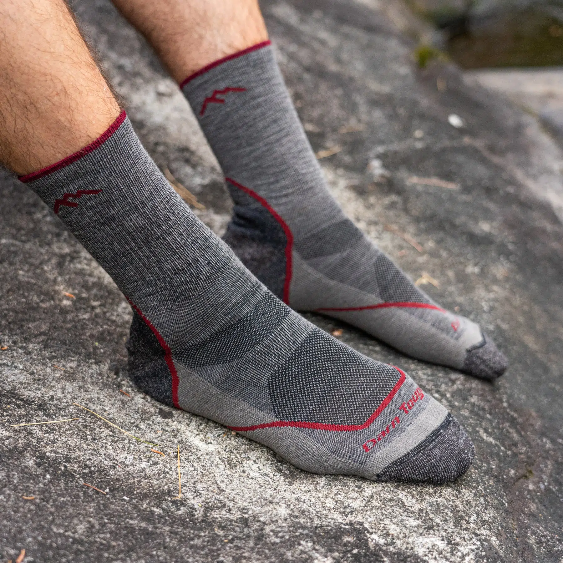 Man standing on rock wearing Darn Tough light hike micro crew socks outdoors
