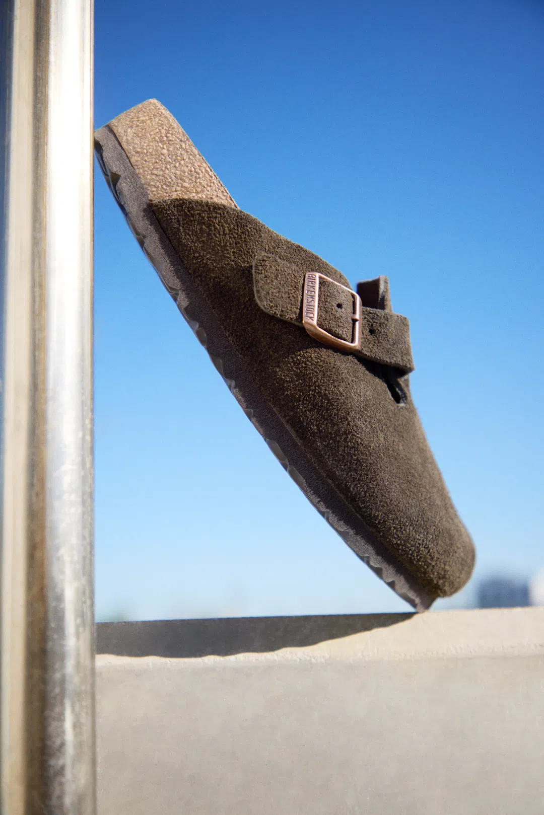 Person wearing Birkenstock Boston Mocha Suede clogs outdoors.