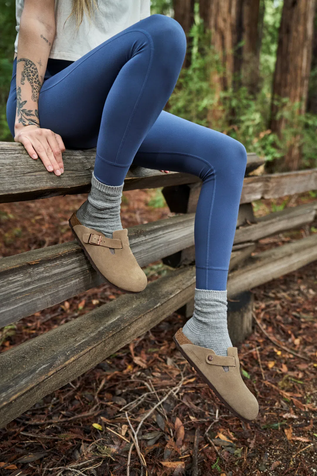 Person wearing Birkenstock Boston Taupe Suede clogs outdoors.